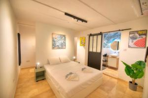 ein Schlafzimmer mit einem großen weißen Bett in einem Zimmer in der Unterkunft Gunlayer Maisonette in Floriana
