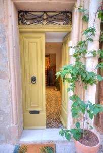 eine gelbe Tür auf einem Gebäude mit einer Topfpflanze in der Unterkunft Gunlayer Maisonette in Floriana