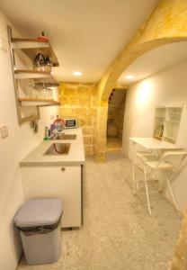 eine kleine Küche mit einem Waschbecken und einem Tisch in der Unterkunft Gunlayer Maisonette in Floriana