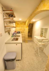 a small kitchen with a sink and a table at Gunlayer Maisonette in Il-Furjana +25 photos