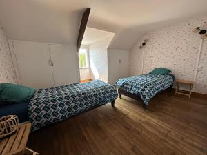 a bedroom with two beds and a window at Chez Tante Muguette proche Dinan in Le Hinglé