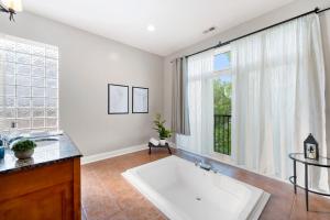 baño con bañera grande y ventana en Spacious Luxury Retreat 8 Bed Oasis with 6 Baths en Chicago