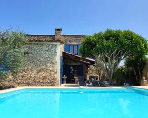 ein großer blauer Swimmingpool vor einem Haus in der Unterkunft "La Massette du Cheval Blanc" Villa de caractère en pierre in LʼIsle-sur-la-Sorgue
