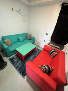 a living room with a red couch and a green table at استديو فى بورتو جولف مارينا in El Alamein