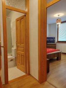 uma casa de banho com uma porta que leva a um quarto em Shiny Thumb Apartment em Bihać