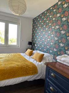 - une chambre avec un lit et un papier peint floral dans l'établissement Grande maison à deux pas de la mer, à Bray-Dunes