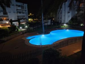 a large blue swimming pool at night at costa ballena elite in Costa Ballena