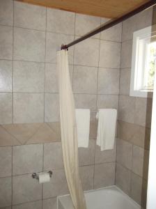 La salle de bains est pourvue d'une douche avec un rideau de douche blanc. dans l'établissement Auberge Mountain View Inn, à Mont-Tremblant
