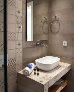 une salle de bain avec un lavabo blanc et un miroir dans l'établissement Santa Maria Mare, à Náoussa