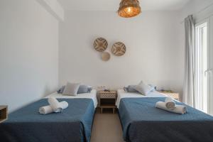 a bedroom with two beds with towels on them at Santa Maria Mare in Naousa