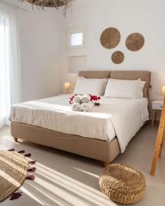 une chambre avec un lit avec des fleurs et deux animaux en peluche dans l'établissement Santa Maria Mare, à Náoussa