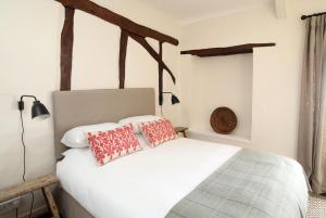 a bedroom with a white bed with two red pillows at Black Lion Hotel in Little Walsingham