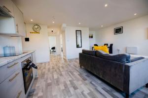 a living room with a couch and a kitchen at PristineRelocation Accommodation in London