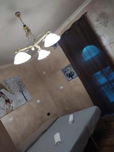Habitación con cama y lámpara de araña. en The New B&B, en Poggio Imperiale