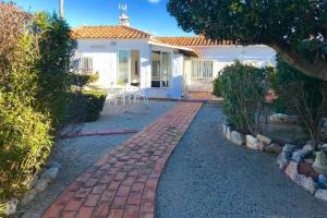 a brick walkway leading to a white house at VILLA PHILIP Piscina privada in Miami Platja