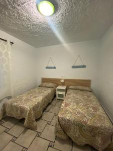 a bedroom with two beds and a ceiling at VILLA PHILIP Piscina privada in Miami Platja +27 photos