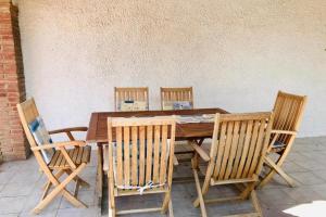 a wooden table with four chairs around it at VILLA PHILIP Piscina privada in Miami Platja