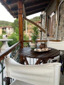 a wooden table and chairs on a balcony at Despina’s House in Sykia Chalkidikis