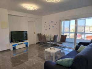 a living room with a blue couch and a tv at Dreams Carthago in Cartagena