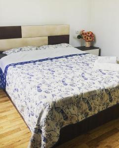 a bed with a blue and white comforter on it at Mira House in Martvili