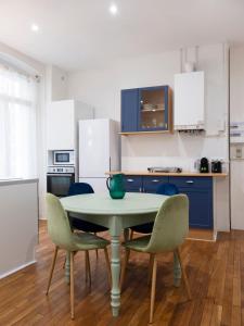 a kitchen with a table and chairs and blue cabinets at Elephant of Gambetta in Metz