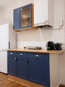 a kitchen with blue cabinets and a wooden counter top at Elephant of Gambetta in Metz