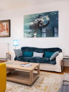 a living room with a blue couch and an elephant painting at Elephant of Gambetta in Metz