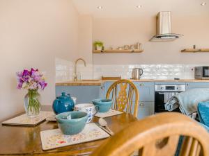 a kitchen with a wooden table with blue bowls on it at The Old Stable At Henley View in Draycott