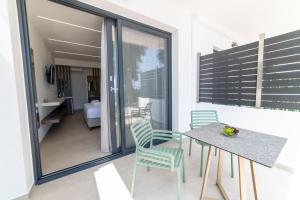a dining room with a table and chairs on a balcony at Lithitsa Lofts and Suites in Parga