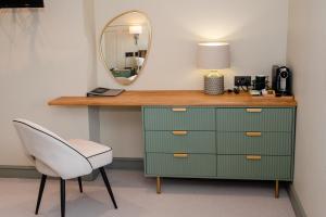 a green dresser with a mirror and a white chair at The Flag in Wivenhoe