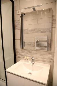 a bathroom with a white sink and a mirror at Mars in Saint-Quentin +3 photos