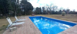 two chairs sitting next to a swimming pool at Rincón Alto Cabañas in Nono
