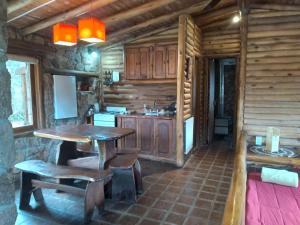 a kitchen with a table and chairs in a cabin at Rincón Alto Cabañas in Nono