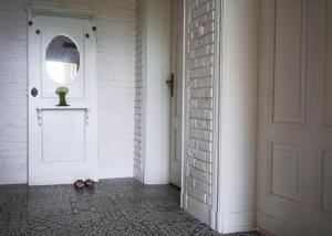 a hallway with a white door and a mirror at Kobieciarnia in Tczew