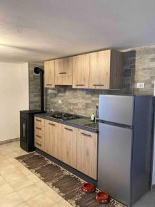 una cucina con frigorifero blu e armadietti in legno di Baita da Gigli a Bianzone