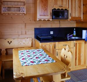 a wooden kitchen with a wooden table and a sink at Domek góralski Zakopane in Zakopane