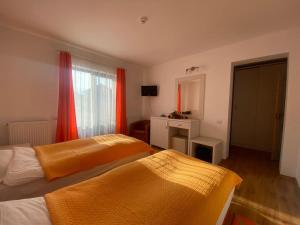 a hotel room with two beds and a mirror at Pensiunea Cassandra in Neagra Şarului