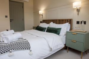 a bedroom with a large white bed with a green night stand at The Flag in Wivenhoe