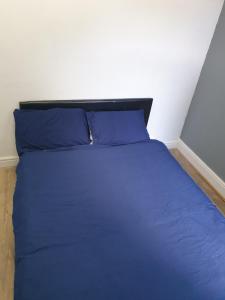 a blue bed with blue pillows in a bedroom at Friendly Stockport in Stockport