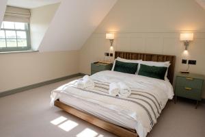 a bedroom with a large bed with towels on it at The Flag in Wivenhoe