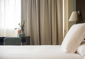 - une chambre avec un lit, un bureau et une fenêtre dans l'établissement AZZ Pamplona Norte Hotel, à Pampelune
