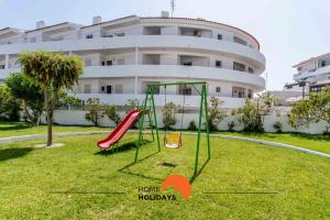 a playground in a yard in front of a building at #167 Santa Eulália by Home Holidays in Branqueira