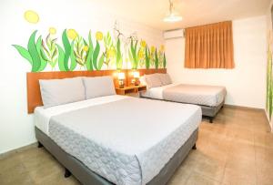 a bedroom with two beds and a mural on the wall at Hotel Caracas in Panama City