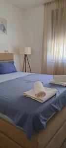 Una cama con dos toallas encima. en Lux Apartment Jovanovic en Tivat