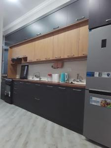 a kitchen with black cabinets and a sink at Apartment in Fergana