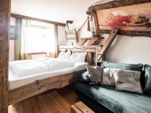 una camera con un grande letto e un divano di Altholz-Apartment a Ramsau