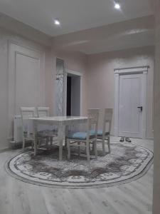 a dining room with a white table and chairs at Apartment in Fergana