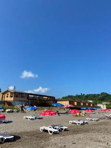 einen Strand mit Liegestühlen und Sonnenschirmen auf dem Sand in der Unterkunft Black Sea Beach Bungalow in Akcakoca