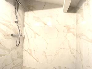 een douche in een badkamer met een witte marmeren muur bij Appartement 3 chambres à proximité des plages in Cannes +17 foto's