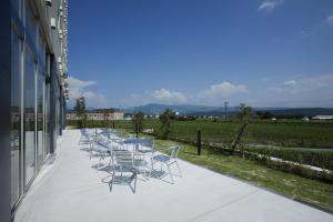 a row of chairs sitting on the side of a building at Candeo Hotels Ozu Kumamoto Airport in Ozu
